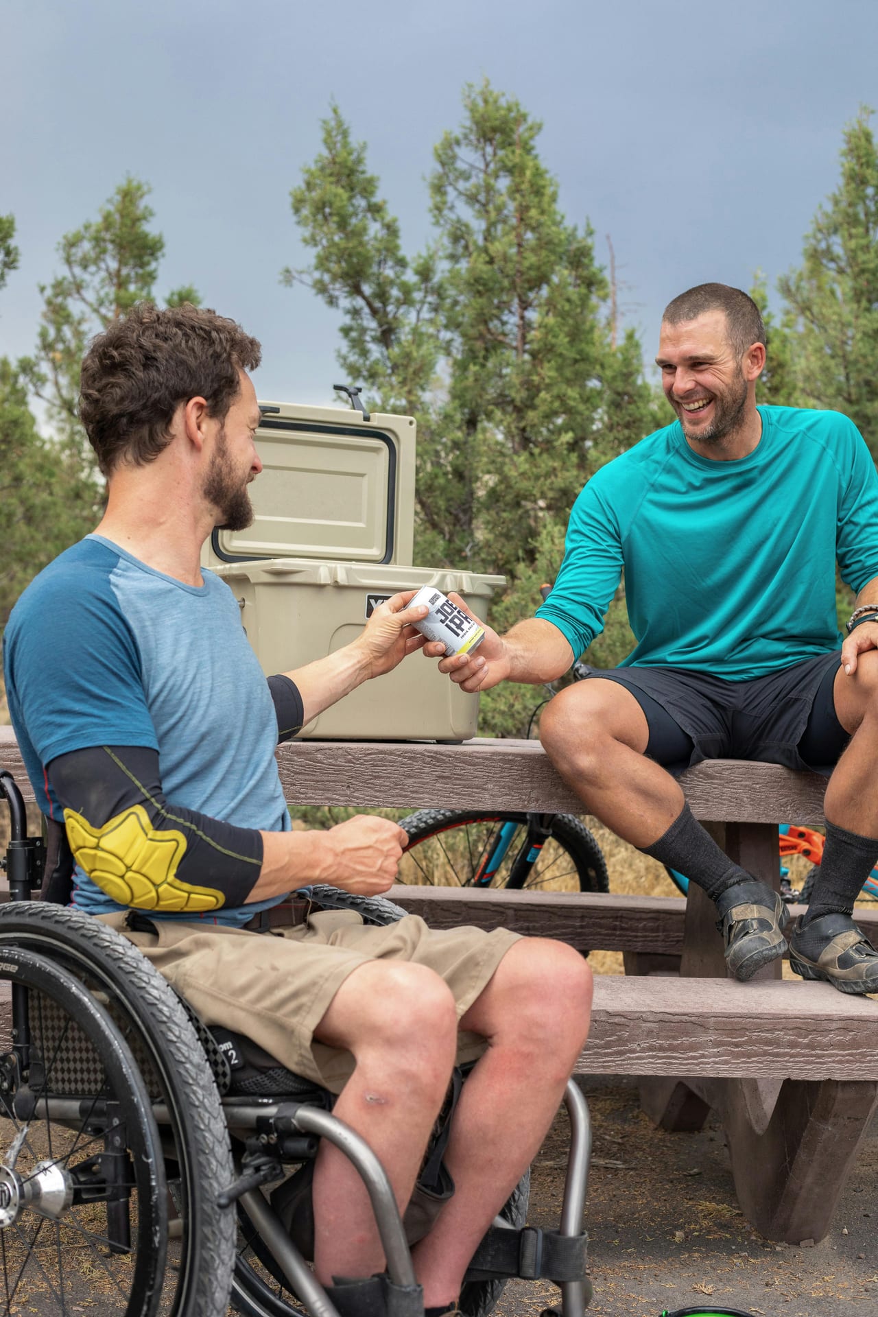 A wheelchair user shares a sporting moment with someone supporting him